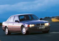 BMW 735i na górskiej drodze o zmierzchu. Ta powściągliwa bryła, ganiona w połowie lat dziewięćdziesiątych za brak prezencji, dziś czyta się jako klasa