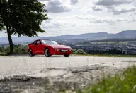Przód i bok czerwonego Porsche 944 w wersji bazowej. Fot. Porsche AG
