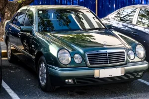 Mercedes E 230 w linii Elegance, egzemplarz pierwszej serii. Cztery owalne reflektory zastąpiły prostokątne klosze W124 i na dekadę stały się twarzą marki. Fot. Ethan Llamas, Wikimedia Commons, CC BY-SA 4.0.