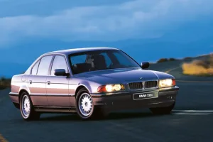 BMW 735i na górskiej drodze o zmierzchu. Ta powściągliwa bryła, ganiona w połowie lat dziewięćdziesiątych za brak prezencji, dziś czyta się jako klasa