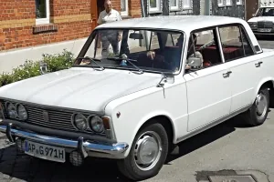 Wczesny Fiat 125p: sylwetka włoskiego Fiata 125, cztery okrągłe reflektory i chromowany zderzak z kłami. Pod maską — mechanika starszej rodziny 1300/1500