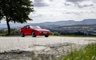 Przód i bok czerwonego Porsche 944 w wersji bazowej. Fot. Porsche AG