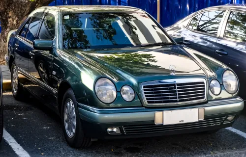 Mercedes E 230 w linii Elegance, egzemplarz pierwszej serii. Cztery owalne reflektory zastąpiły prostokątne klosze W124 i na dekadę stały się twarzą marki. Fot. Ethan Llamas, Wikimedia Commons, CC BY-SA 4.0.