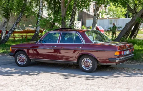 Mercedes W123 sedan na zlocie w Püttnitz (2018); wiśniowy lakier, chromy i kołpaki w bardzo dobrym stanie. Niemiecka tablica odpowiada formatowi tablicy zabytkowej „H”. Zdjęcie: Matti Blume, CC BY-SA 4.0