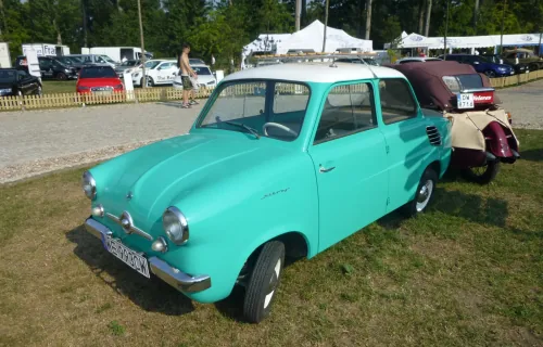 Mikrus MR-300 w turkusowym kolorze z białym dachem na trawie, ujęcie trójćwarte z przodu i lewego boku, na polskich tablicach; w tle zlot zabytkowych pojazdów. Fot. MartinHansV, Wikimedia Commons, licencja CC BY 3.0