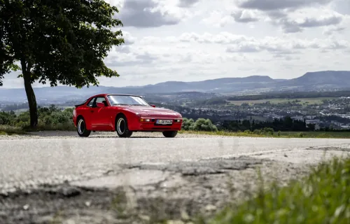 Przód i bok czerwonego Porsche 944 w wersji bazowej. Fot. Porsche AG