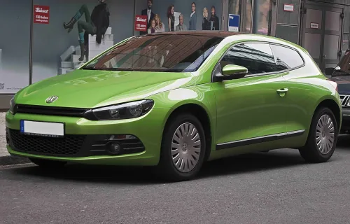 Volkswagen Scirocco III sprzed liftingu w zielonym lakierze Viperngrün — ujęcie 3/4 z przodu, seryjne kołpaki i ciemny dach, egzemplarz zaparkowany przy ulicy.