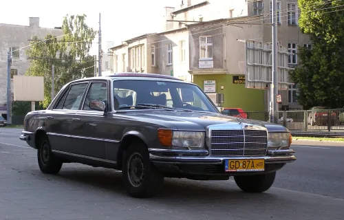 Mercedes-Benz 450 SEL (W116) na ulicy w Gdańsku, z przodu polska żółta tablica zabytkowa GD 87A z piktogramem pojazdu historycznego