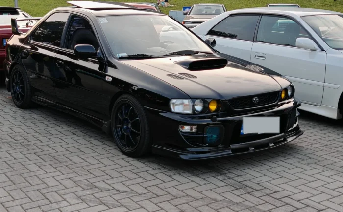 Subaru Impreza pierwszej generacji na zlocie Krakowskie Klasyki Nocą w 2025 r. Takie auta z lat 90. bywają nazywane youngtimerami, choć polskie prawo tego słowa nie zna.