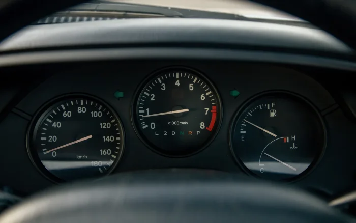 Prędkościomierz kończy się na 180 km/h i nie jest to pomyłka. Tyle wynosił limit narzucony japońskim autom przez samych producentów — elektronika pilnowała go skuteczniej niż policja.