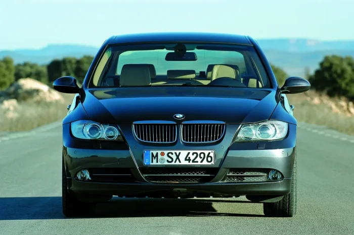 Ciemne BMW 330i generacji E90 pokazane centralnie od przodu.