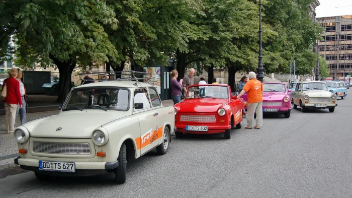 Kolumna trabi-safari przed wyjazdem w miasto. Druga kariera Trabanta: turyści za kierownicą, przewodnik w pierwszym aucie.