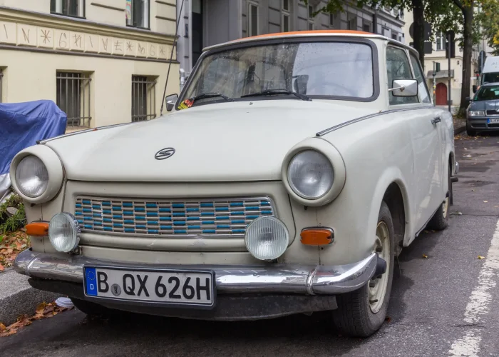 Trabant 601 de luxe na berlińskich tablicach zabytkowych. Dwubarwne nadwozie i chrom — górna półka drabinki wersji, dziś codzienny klasyk.